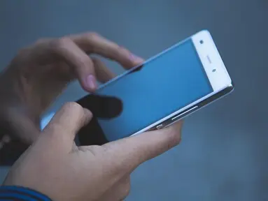 Persona revisando un celular sostenido con ambas manos