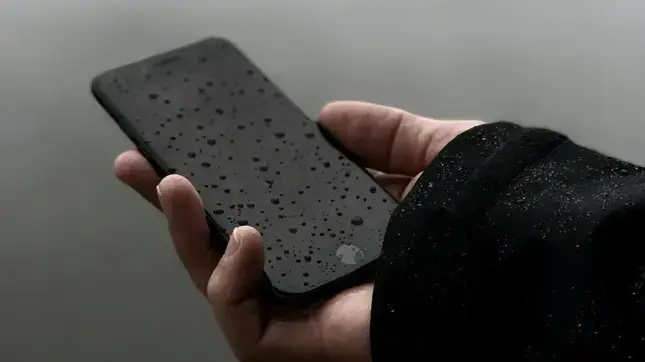 Celular mojado con gotas de agua en la pantalla