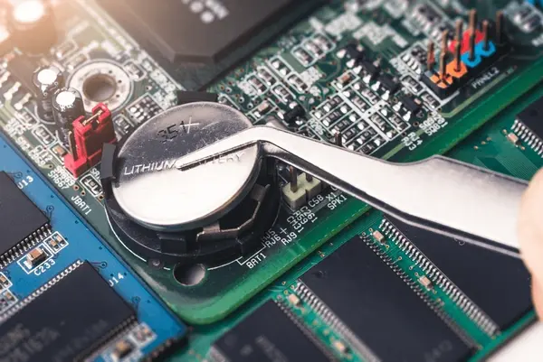 Técnico revisando la batería de una placa base