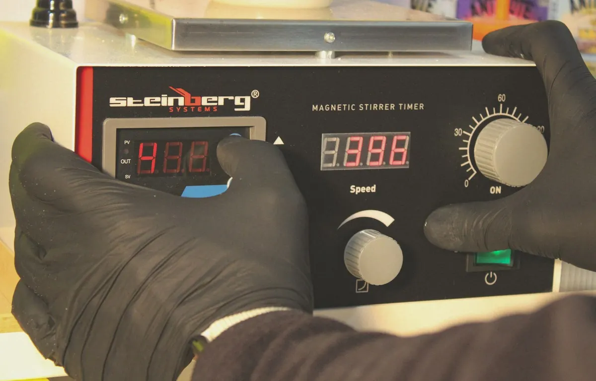 Técnico con guantes manejando un agitador magnético de laboratorio