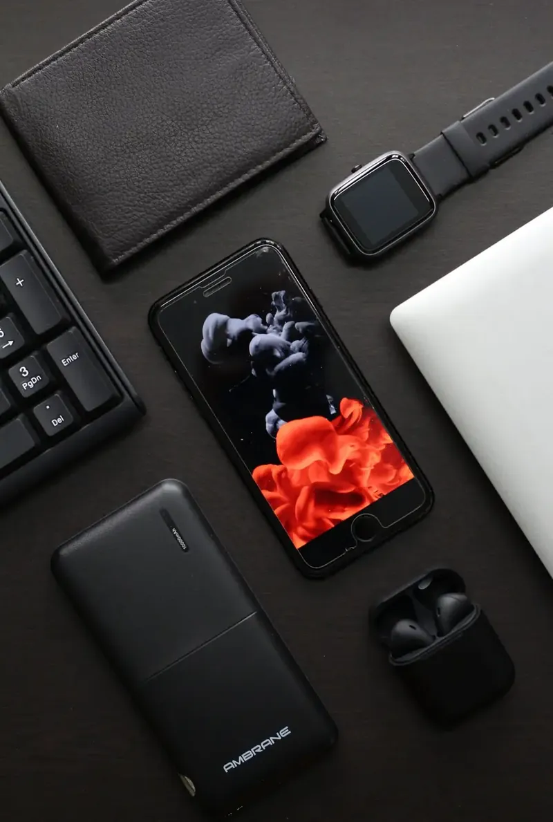 Accesorios para celular: cargador, auriculares y fundas sobre un escritorio