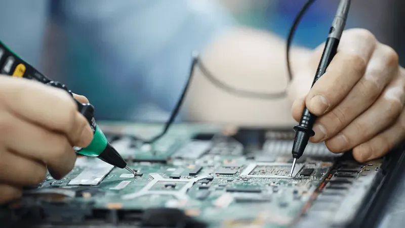 Técnico soldando componentes en una placa electrónica